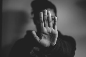 Collateral Consequences of Domestic Violence in Georgia - Marietta Attorneys Dean Phillips Law Office Adult raising a hand defensively, representing the lasting consequences of a domestic violence conviction in Georgia