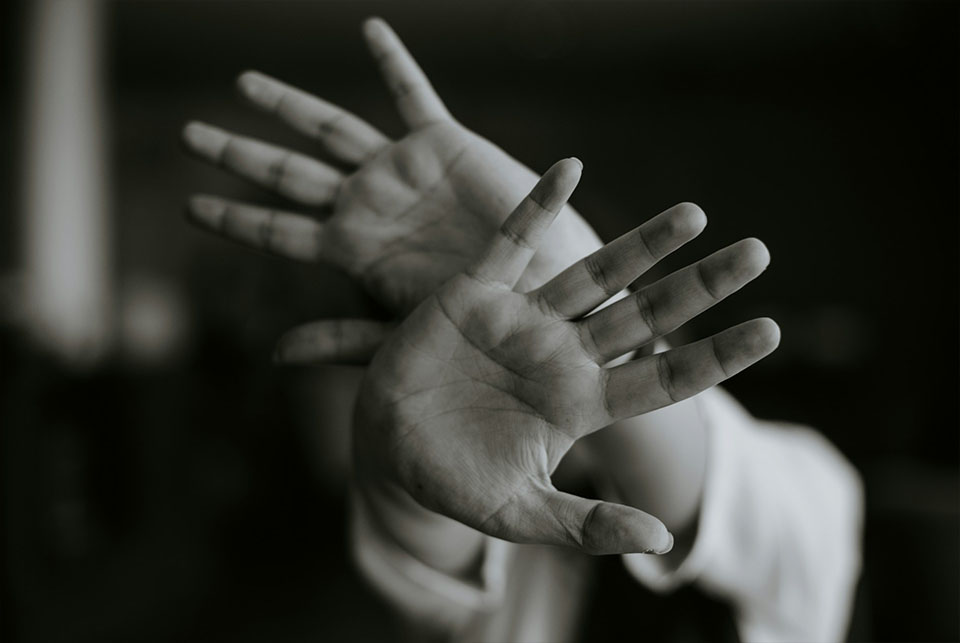 Adult raising both hands defensively, representing domestic violence and protective order cases in Georgia