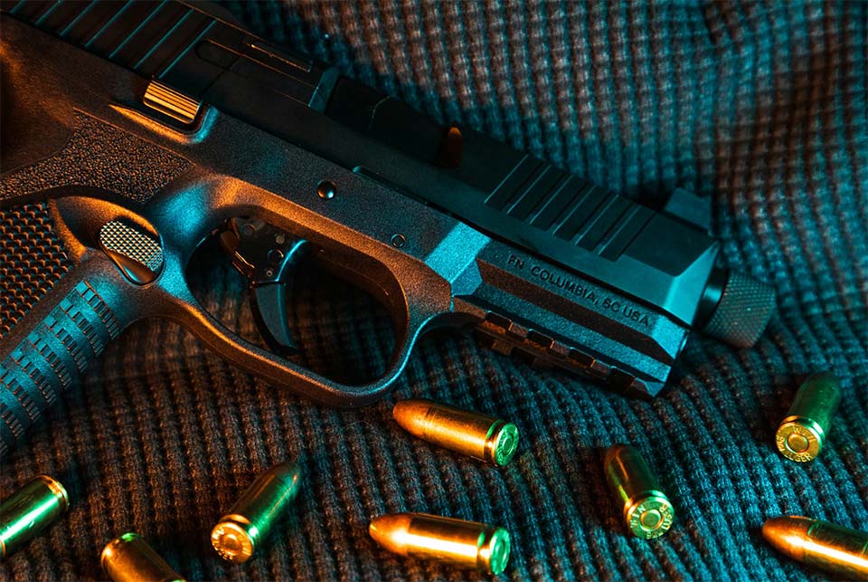 Close-up of a handgun and bullets representing Georgia gun laws, firearm possession restrictions, and criminal charges