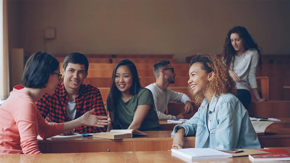 College students sitting together and talking in a university setting, illustrating campus life, student safety, and social interactions in Georgia